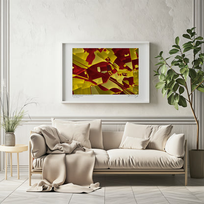 Affiche fine art représentant une carte géographique abstraite du stade Bollaert-Delelis et ses alentours, à Lens, France, dans des tons rouges et jaunes, présentée encadrée au-dessus d’un canapé beige dans un intérieur lumineux et minimaliste.