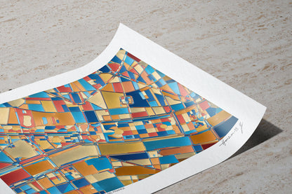 Tirage d’art de la carte abstraite de la Place de la Concorde et des Tuileries posé sur une surface pierre claire, coin du papier délicatement relevé, révélant la texture du papier d’art et les couleurs bleu, or, rouge et ocre de la composition.