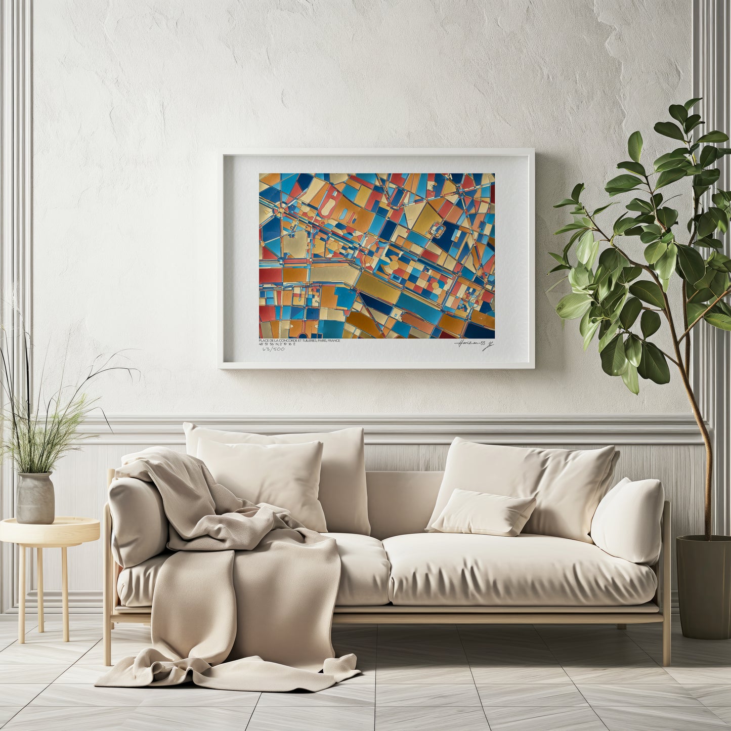 Affiche fine art représentant une carte géographique abstraite de la Place de la Concorde et du Jardin des Tuileries à Paris, dans des tons bleu, or, rouge et ocre, encadrée et accrochée au-dessus d’un canapé beige dans un intérieur élégant et lumineux.