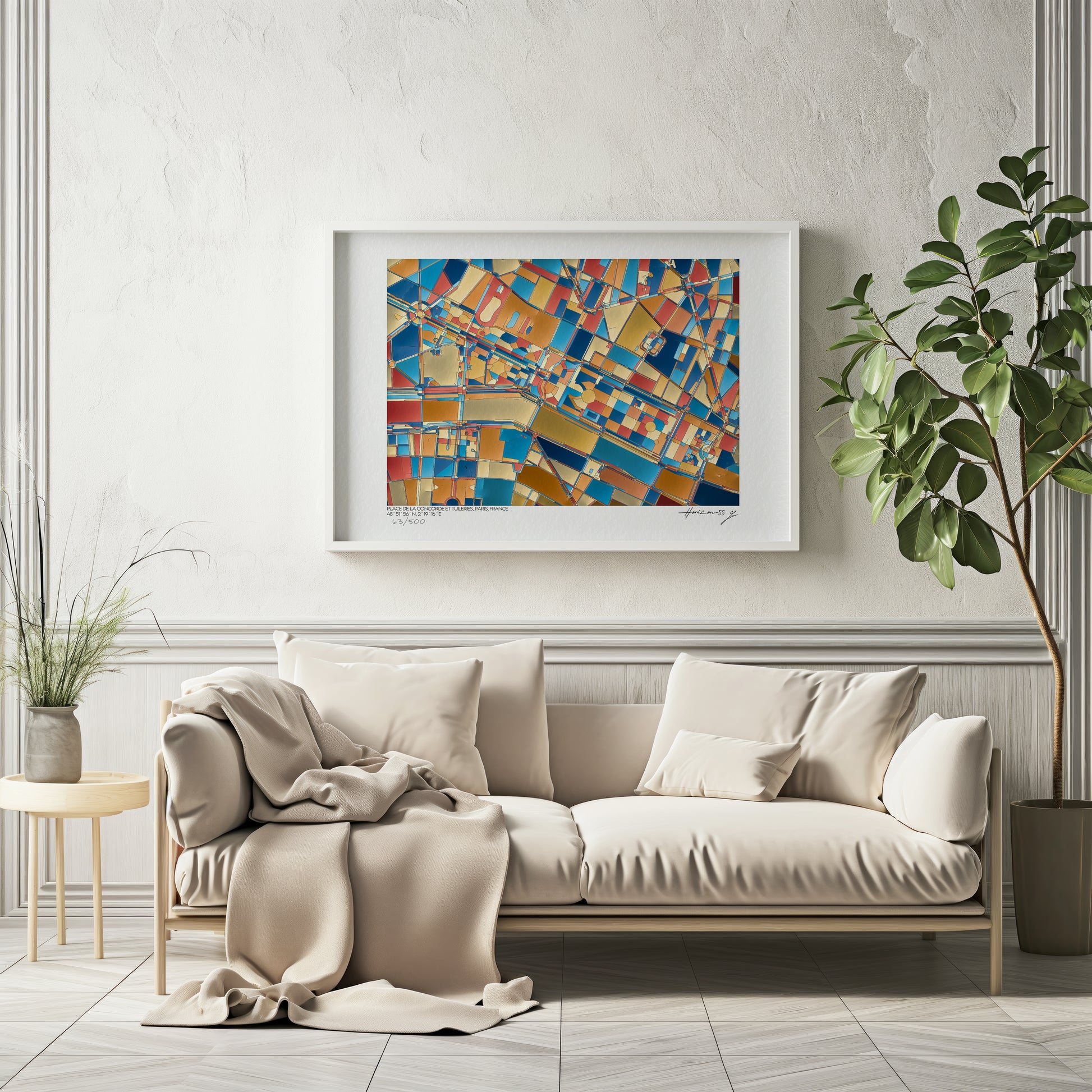 Affiche fine art représentant une carte géographique abstraite de la Place de la Concorde et du Jardin des Tuileries à Paris, dans des tons bleu, or, rouge et ocre, encadrée et accrochée au-dessus d’un canapé beige dans un intérieur élégant et lumineux.