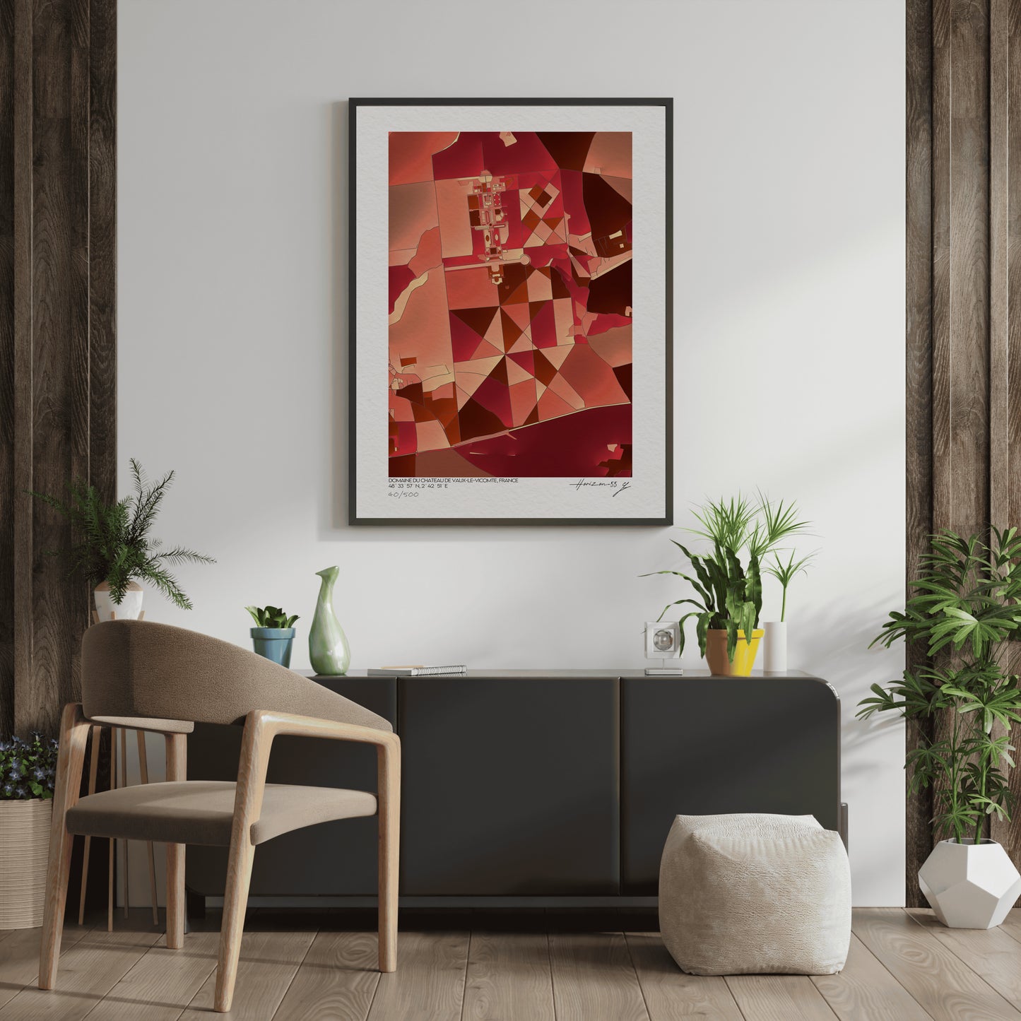 Affiche fine art représentant une carte géographique abstraite du domaine de Vaux-le-Vicomte, dominée par des nuances rouges et ocres, encadrée et exposée dans un intérieur élégant avec plantes vertes et mobilier contemporain.