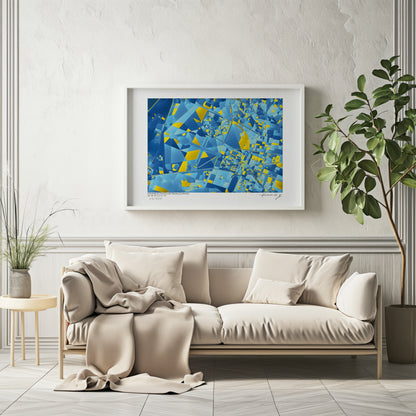 Carte abstraite bleue et jaune du Domaine du Château de Versailles, encadrée et accrochée au-dessus d’un canapé beige dans un intérieur lumineux et élégant.