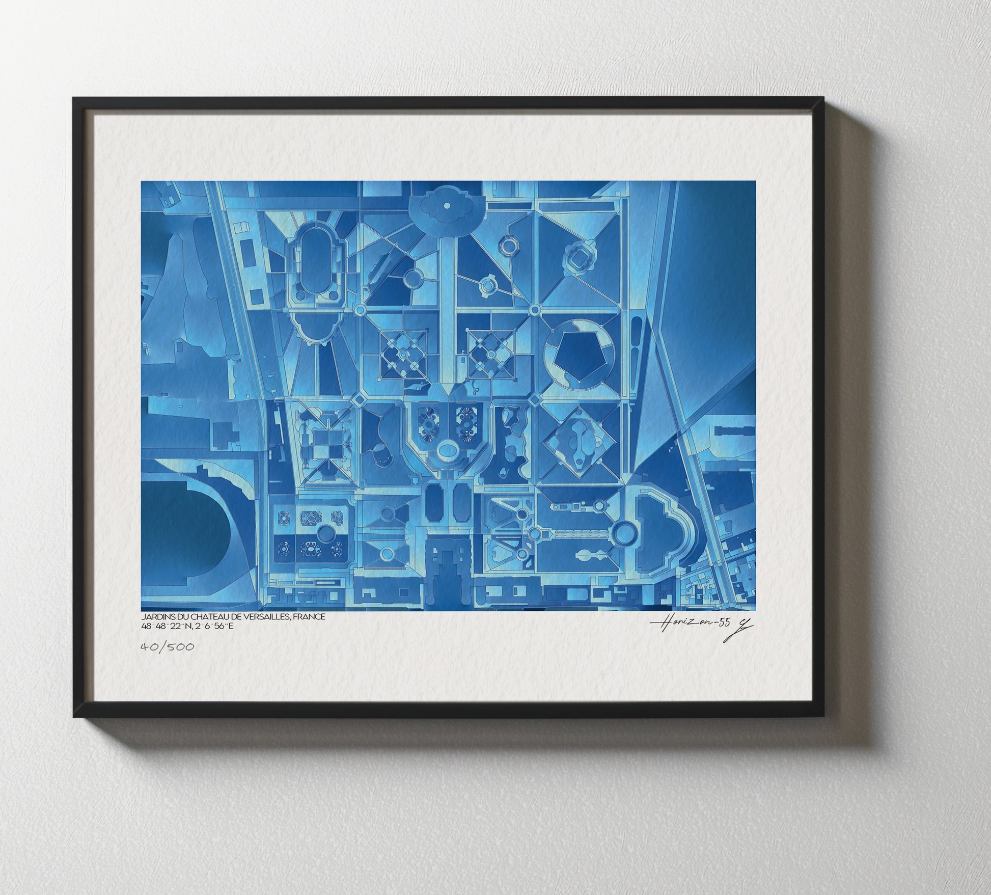 Affiche encadrée illustrant une interprétation géographique abstraite des Jardins du Château de Versailles, France, vue de face sur un mur clair, mettant en valeur les détails bleutés de la composition.